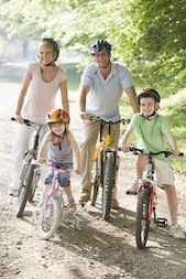 Family sitting on bikes on path smiling