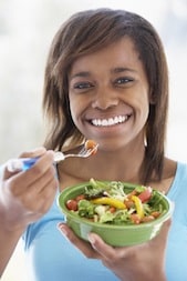 Teenage Girl Holding A Bowl Of Salad And Smiling At The Camera